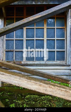 Altes Gebäude mit schmutzigen Fenstern und einem moosigen Äußeren Stockfoto