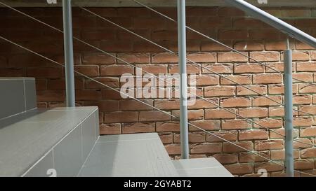 Rotes Ziegelgebäude mit einer modernen Treppe im Loft-Stil mit Metallgeländer. Treppen schmücken das Gebäude. Modernes Treppenhaus. Stahlgeländer. Treppe i Stockfoto