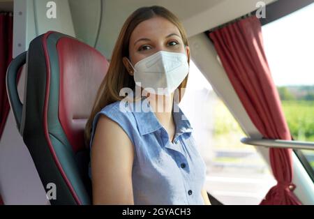 Attraktive lächelnde Beifahrerin im Bus, die die Kamera anschaut Stockfoto