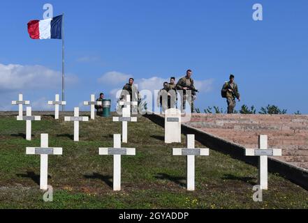 Französische Soldaten auf dem Weg durch die Kriegsgräber auf dem nationalen Kriegsfriedhof von Sigolsheim im Elsass in Frankreich. Es enthält die Stockfoto