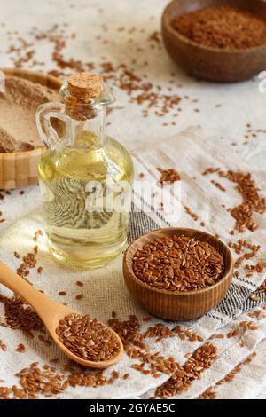 Rohe Leinsamen Mehl, Öl und Samen mit einem Löffel schließen sich auf den weißen Tisch Stockfoto
