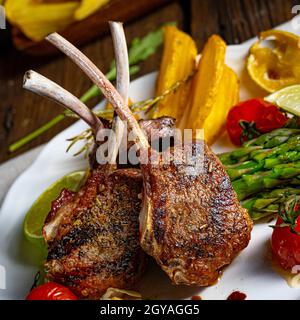 Lammkoteletts in Kräutern mit grünem Spargel und Limette mariniert Stockfoto