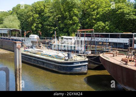 Barges vertäuten bei Isleworth Ait an der Themse und eines mit einem Schmalboot darüber Stockfoto