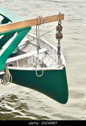 Altes hölzernes Rettungsboot, das an der Seite eines hohen Segelschiffs gehisst wurde. Stockfoto