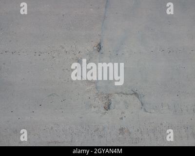 Schlaglöcher auf dem Asphalt. Hintergrund einer kaputten Straße mit Schlaglöchern und Restaurierungspatches. Konzept für Design. Die Textur der beschädigten Straßenoberfläche Stockfoto