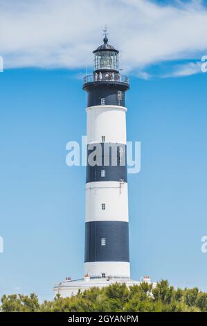 Der Chassiron Leuchtturm mit schwarzen und weißen Streifen am blauen Himmel, auf der Insel Oléron in Frankreich Stockfoto