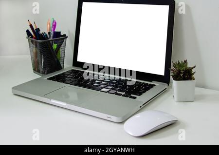 Computerlaptop mit weißer Farbe und Maus auf dem Schreibtisch. Verwendet, um Text oder Informationen zu setzen, um Nachrichten zu werben oder Produkte online zu verkaufen Stockfoto