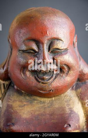 Traditionelle Holzstatue des chinesischen Buddha isoliert auf dunklem Hintergrund Stockfoto