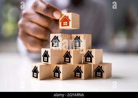 Real Estate House Gemeinschaft. African Man Stacking Housing Blocks Stockfoto