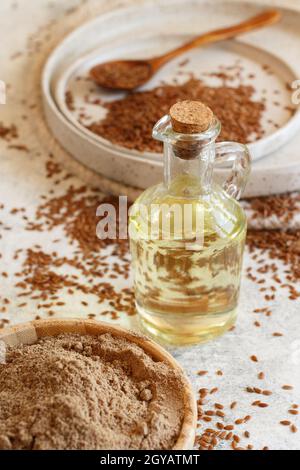 Rohe Leinsamen Öl, Mehl und Samen schließen sich auf dem weißen Tisch an Stockfoto