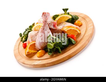 Rohe Schweinekoteletts auf Schneidebrett und Gemüse Stockfoto