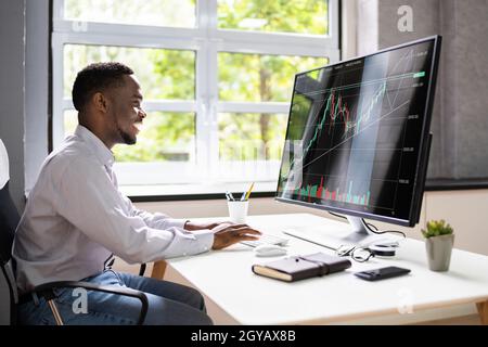 African American Man Trading Stock Market Online Auf Computer Stockfoto