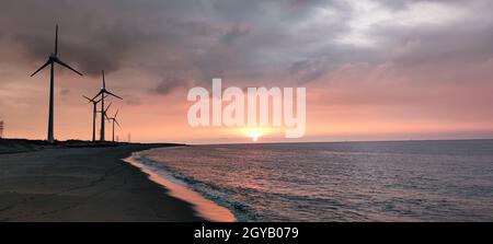 Die Sillouette der Windturbinen-Anlage am Meeresufer Stockfoto