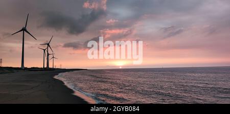 Die Sillouette der Windturbinen-Anlage am Meeresufer Stockfoto