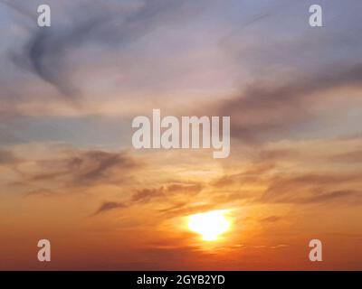 Wunderschöne, trübe Sonne unter den Wolken bei Sonnenuntergang. Stockfoto