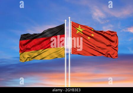 China und Deutschland zwei Flaggen auf Fahnenmasten und blau bewölkt Himmel Stockfoto