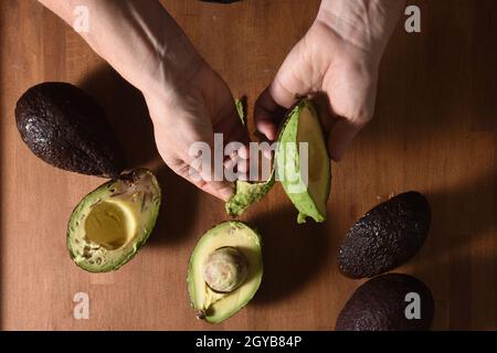 Aus der Sicht eines Kochs, der eine Avocado schält Stockfoto
