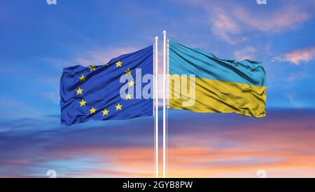 Ukraine und Europäische Union zwei Flaggen auf Fahnenmasten und blau Himmel Stockfoto