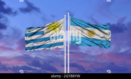 Argentinien und Uruguay zwei Flaggen auf Fahnenmasten und blauer Himmel Stockfoto