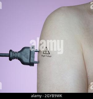 Ein Mann, der mit einem Stecker an den Strom in seinem Arm angeschlossen war Stockfoto