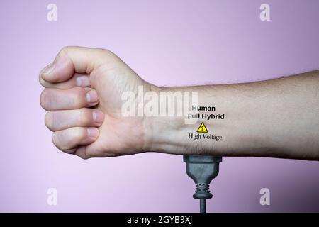 Ein Mann, der mit einem Stecker an den Strom in seinem Arm angeschlossen war Stockfoto