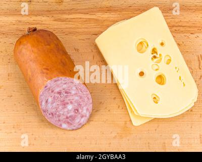 Sandwich mit Wurst und Hartkäse auf einem Schneidebrett. Butter mit Brot. Küchenmesser. Küchentisch. Platz für Text. Stockfoto