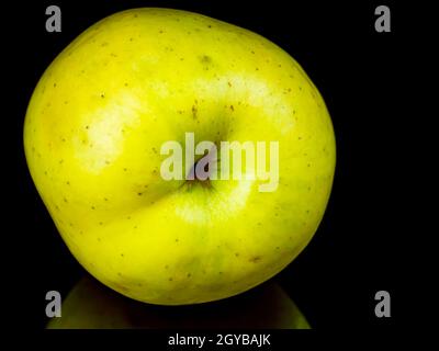 Grüne apfelfrucht auf schwarzem Glashintergrund mit Spiegelung. Hintergrundbild. Lebensmittelfoto. Platz für Text. Äpfel Golden. Apfelsaft. Stockfoto