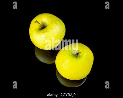 Grüne apfelfrucht auf schwarzem Glashintergrund mit Spiegelung. Hintergrundbild. Lebensmittelfoto. Platz für Text. Äpfel Golden. Apfelsaft. Stockfoto