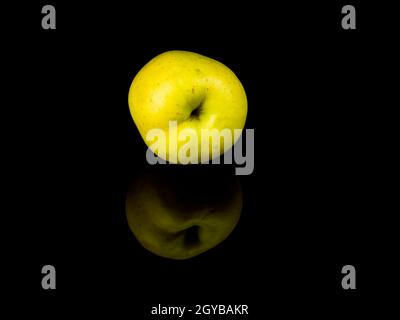 Grüne apfelfrucht auf schwarzem Glashintergrund mit Spiegelung. Hintergrundbild. Lebensmittelfoto. Platz für Text. Äpfel Golden. Apfelsaft. Stockfoto