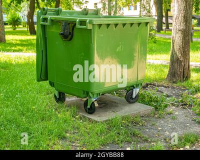 Grüner Plastikmüllbehälter in einem öffentlichen Park. Umwelt. Stadtleben. Im Freien. Natürliche Bedingungen. Für Text platzieren. Hintergrundbild. Ökologie. Stockfoto