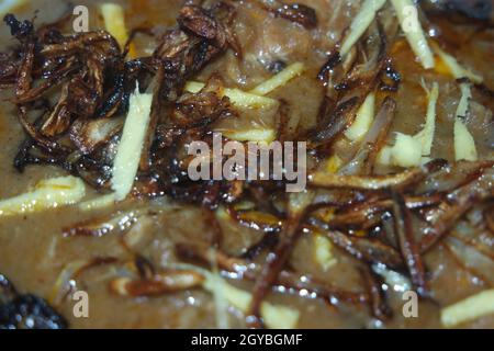 Nahaufnahme des traditionellen pakistanischen Haleem-Gerichts mit Salat und Zitronensaft. Stockfoto