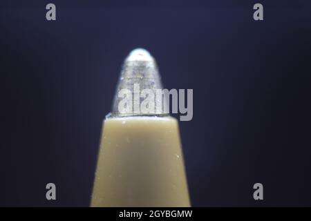 Makrofoto der Kugelschreiber-Spitze mit dunkelgrauem Hintergrund. Extremes Makrobild eines Kugelschreibers aus Metall auf grauem Hintergrund. Stockfoto