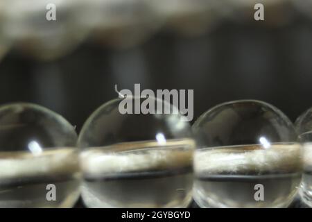 Makro-Fotografie mit selektivem Fokus aus glasglänzenden Gebetsperlen oder Rosenkranz mit Kopierraum für Text. Religion Konzept von ramadan oder Eid für muslime. Stockfoto