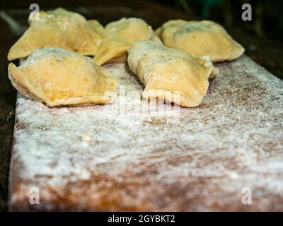 Ukrainische Knödel mit Teig gefüllt auf einem Schneidebrett. Knödel. Kochen von Speisen. Food-Foto. Rezept. Schaufenster. Poster. Vorlage mit Platz für t Stockfoto