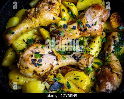 Bratkartoffeln mit Hühnerschenkel gewürzt mit Kräutern. Bratkartoffeln. Hühnerfleisch. Kartoffelbraten mit Geflügel. Vogelpfote. Speisekarte. Wohnküche. Coo Stockfoto