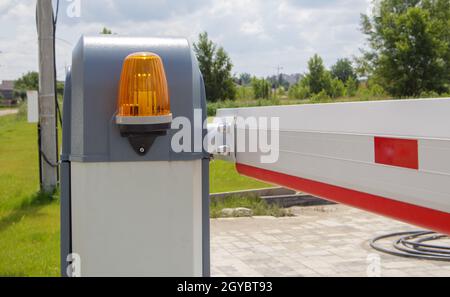 Schließen Sie das Tor. Automatisches Sicherheitssystem. Automatisches Eintrittssystem. Gelbes Lichtsignal mit einer Straßenbarriere. Schrankentore Automatisches Sicherheitssystem Stockfoto