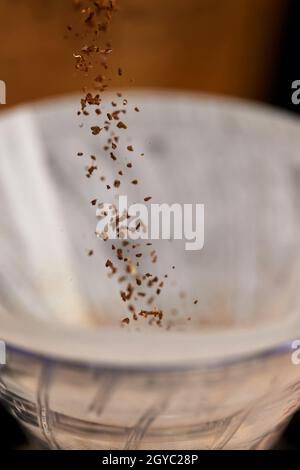 Männliche Hände gießen im Café gemahlenen Kaffee in den Filter. Stockfoto