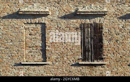 Detail der Ziegelfassade mit Fenstern im alten Haus, Viadana, Italien. Hochwertige Fotos Stockfoto