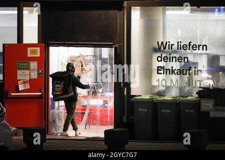 Lieferfahrer/Fahrer vor dem Lieferlager des Lieferdienstes Gorillas in Dortmund, Deutschland. Der Lieferservice verspricht, Lebensmittel in weniger als 10 Minuten per Fahrrad zu liefern.Lieferfahrer/Rider vor dem Auslieferungslager des Lieferdiensts Gorillas in Dortmund. Der Lieferdienst spricht, Lebensmittel in unter 10 Minuten mit dem Fahrrad zu liefern. Stockfoto