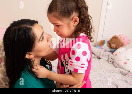 Mutter tröstet die 5-jährige Tochter und weint während eines schwierigen emotionalen Moments Stockfoto