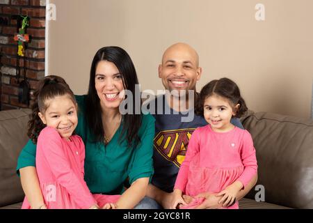 Ehepaar zu Hause mit Töchtern im Alter von 5 und 3 Jahren Stockfoto