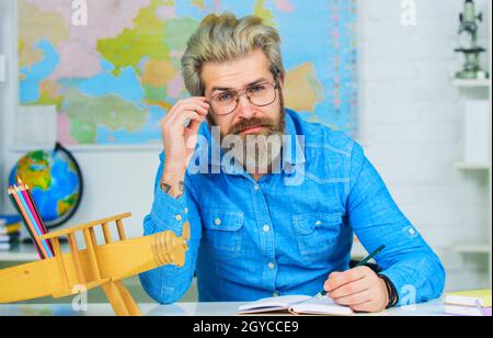 Männlicher Lehrer bereitet den Unterricht im Klassenzimmer vor. Lernen, Bildung, Schulkonzept. Zurück zur Schule Stockfoto