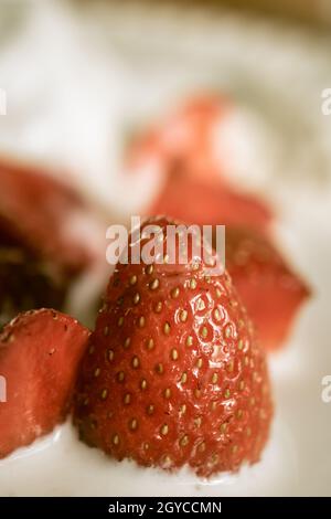 Eine Nahaufnahme in satten Farben von Erdbeeren und Eis. Verschwommener Hintergrund. Hochwertige Fotos Stockfoto