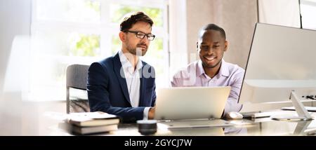 Afroamerikanischer Geschäftsmann Mitarbeiter, Der Mit Einem Kollegen Im Büro Arbeitet Stockfoto