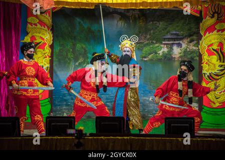 Bangkok, Thailand. Oktober 2021. Mitglieder der chinesischen Operntruppe, die als vorbeugende Maßnahme gegen die Ausbreitung des Coronavirus Gesichtsmasken trägt, treten während des jährlichen vegetarischen Festivals in Bangkok im Chow Sue Kong-Schrein auf.das Vegetarische Festival, Die von chinesischen Einwanderern ins Leben gerufen wurde, findet im neunten Mondmonat statt und dauert neun Tage. Während der neuntägigen Periode werden sich eifrige Anhänger vom Verzehr von Fleisch enthalten, nur vegetarisches Essen konsumieren und Verdienste leisten, alles in der Hoffnung, ihren Körper und Geist zu reinigen. Kredit: SOPA Images Limited/Alamy Live Nachrichten Stockfoto