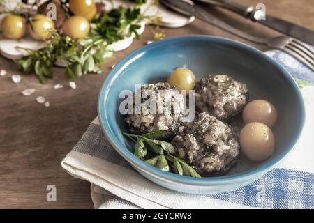 Europäische Küche: Pilze gefüllt mit Fleisch mit Reis, Zwiebeln und im Ofen gebacken. Neben ihm stehen gelbe Tomaten auf einem Teller. Vorderansicht, c Stockfoto