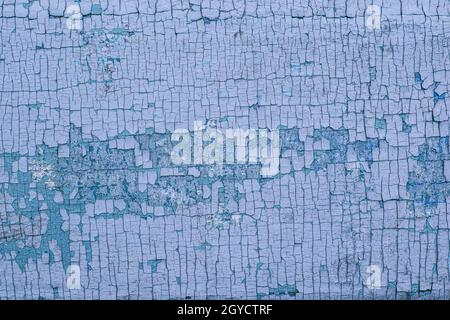Teil einer hölzernen Oberfläche mit rissiger blauer Farbe Stockfoto