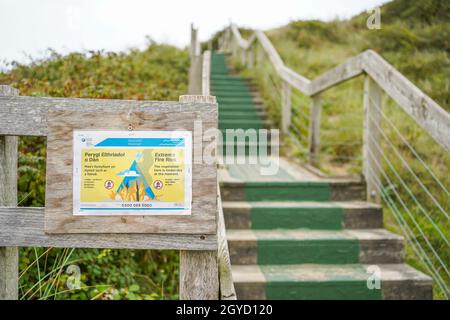 Walisisches Brandrisiko-Schild auf einer Promenade, die zu einem Strand führt. Stockfoto