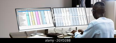 African Data Analyst Man Using Spreadsheet On Computer Stockfoto