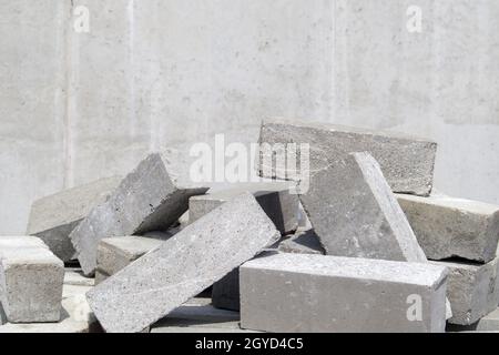 Ein Haufen Zementziegel. Für den Bau wird massiver Ziegel verwendet. Viele lose Betonsteine auf der Baustelle Stockfoto